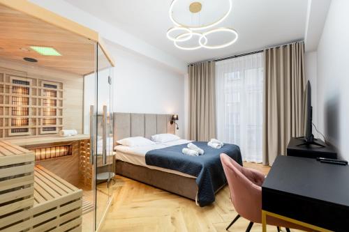 Schlafzimmer mit einem Bett, einem Schreibtisch und einem TV in der Unterkunft Luxury apartment with a sauna and bedroom with bath in Krakau