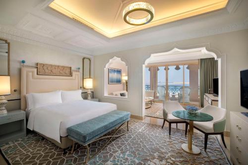 a bedroom with a bed and a living room at Waldorf Astoria Ras Al Khaimah in Ras al Khaimah