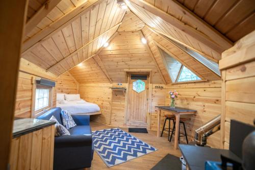 a log cabin with a bed and a table at Chestnut Tree House with Hot tub & Sauna in Barmouth