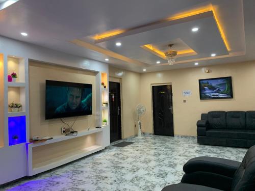 a living room with a couch and a flat screen tv at Umbrella properties - Eleyele Ibadan in Ibadan