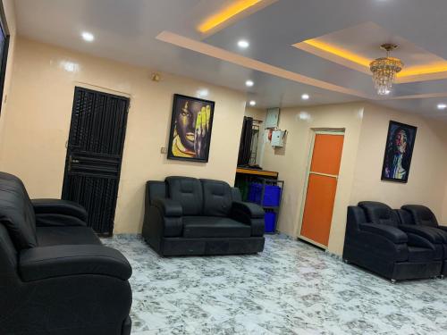 sala de estar con 2 sillas y sofá en Umbrella properties - Eleyele Ibadan, en Ibadán