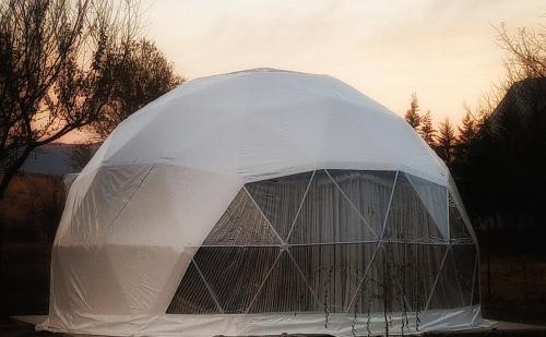 Ze Oni Glamping في تبليسي: خيمة قبة بيضاء مع السماء في الخلفية