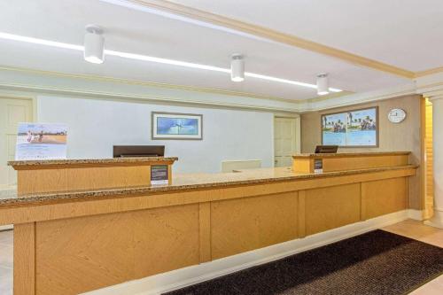 a waiting room with a desk and a reception counter at La Quinta Inn by Wyndham Orlando Airport West in Orlando