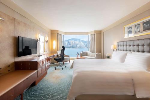 a hotel room with a large bed and a television at Kowloon Shangri-La, Hong Kong in Hong Kong
