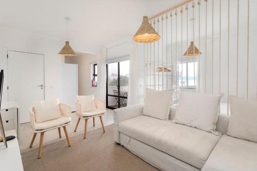 a living room with a white couch and two chairs at TAC - Sagres Studio in Sagres
