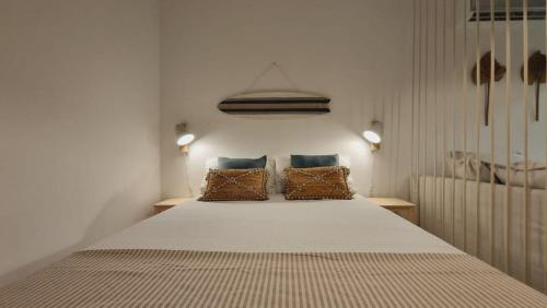 a bedroom with a large bed with two pillows at TAC - Sagres Studio in Sagres