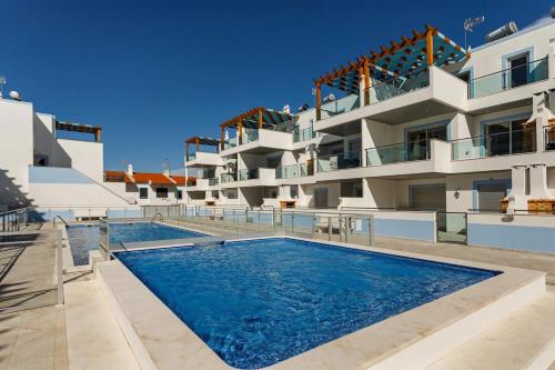 a swimming pool in front of a building at The Albufeira Concierge - Rêve d'été in Vila Nova De Cacela