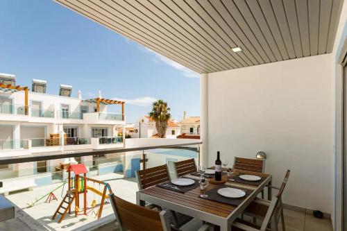 a dining room with a table and chairs next to a pool at The Albufeira Concierge - Rêve d'été in Vila Nova De Cacela