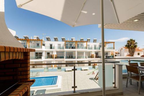a view of a hotel with a pool and a building at The Albufeira Concierge - Rêve d'été in Vila Nova De Cacela