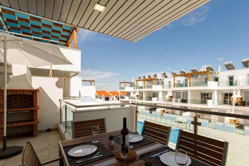 a patio with a table and chairs and a pool at The Albufeira Concierge - Rêve d'été in Vila Nova De Cacela