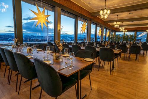 a dining room with tables and chairs and large windows at Radisson Blu Resort, Beitostølen in Beitostøl