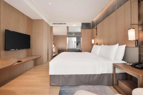 a hotel room with a large bed and a television at DoubleTree by Hilton Taipei Zhongshan in Taipei
