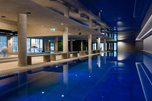 a swimming pool in a building with blue lighting at Radisson Blu Resort & Conference Center, Ostróda Mazury in Ostróda