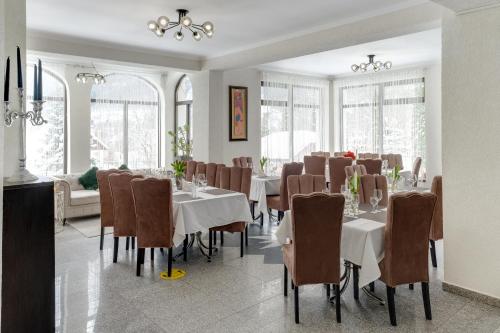 a dining room with tables and chairs and windows at Oana Boutique CDI in Bran