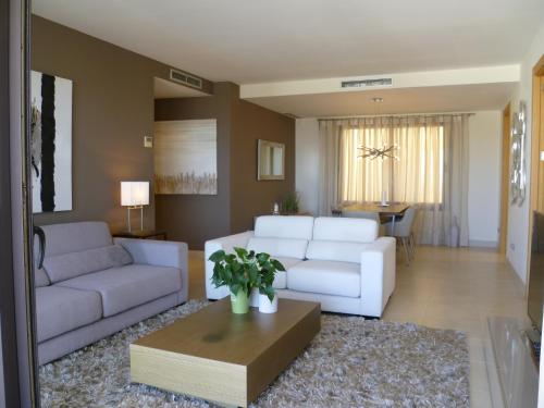 マルベーリャにあるLuxurious Apartment With Spa Areaのリビングルーム(白いソファ2台、テーブル付)