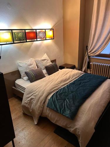 een slaapkamer met een groot bed met 4 kussens bij cozy in Montbéliard
