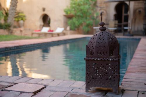 a metal object next to a swimming pool at Dar Les Dattiers in Taroudant