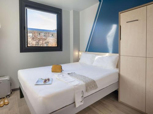 a bedroom with a large white bed with a window at ibis budget Valencia Centro Puerto in Valencia