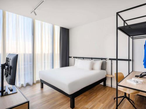 a bedroom with a bed and a desk with a computer at ibis Budapest Stadium in Budapest