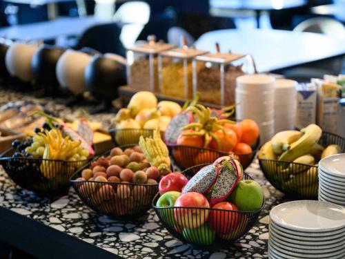 a bunch of bowls of fruit on a table at ibis Budapest Stadium in Budapest