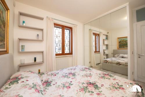 a bedroom with a bed with a floral bedspread at Appartamento Giada in Padenghe sul Garda
