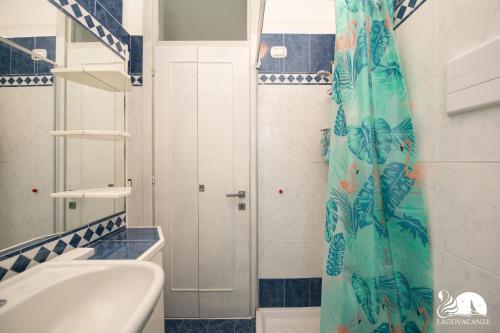a bathroom with a shower curtain and a sink at Appartamento Giada in Padenghe sul Garda