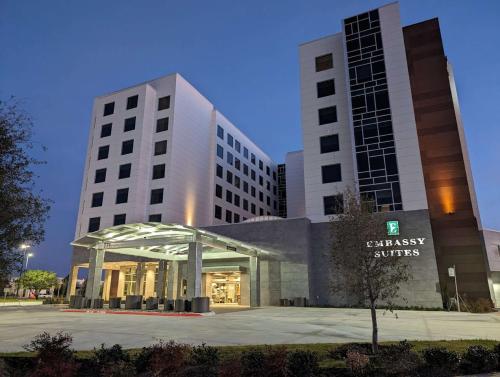 a large building with a sign in front of it at Embassy Suites By Hilton Irving Las Colinas in Irving