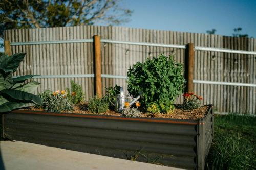 a wooden fence with a flower garden in front of it at Whisky @ On The Rocks in Rock Valley