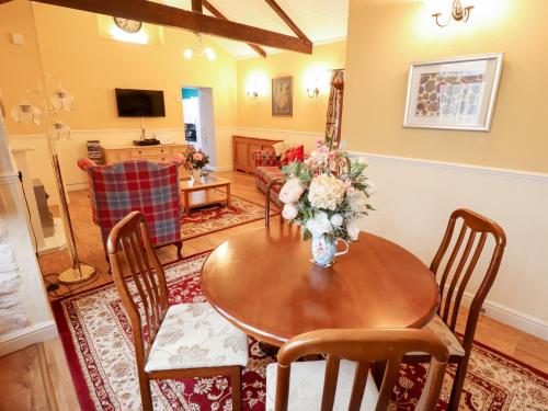a living room with a table with a vase of flowers at The Barn in Snitterby