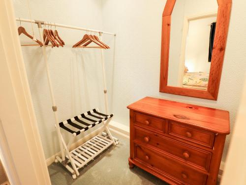 a bathroom with a wooden dresser and a mirror at The Barn in Snitterby