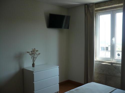 1 dormitorio con tocador y TV en la pared en Casa Das Morgadas, en Nelas