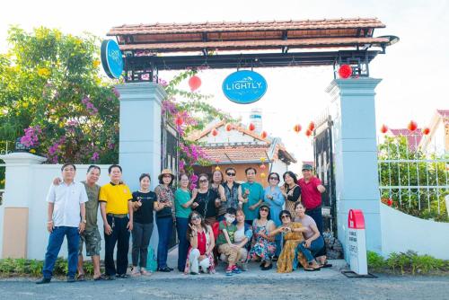 a group of people posing for a picture in front of a gate at Lightly Homestay in Ho Coc