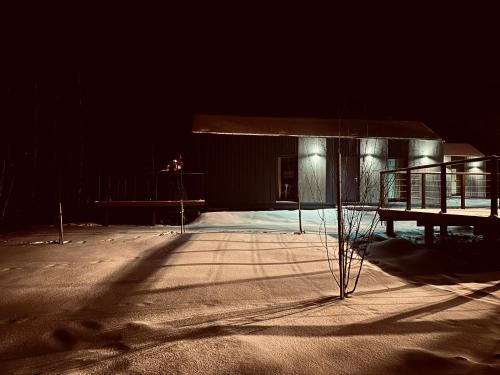 a building at night with a bench in the snow at Domki Piwniczna in Piwniczna