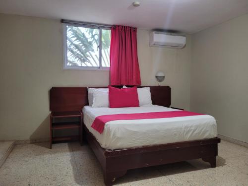 1 dormitorio con 1 cama grande y cortina roja en Hotel Olimpo en La Romana