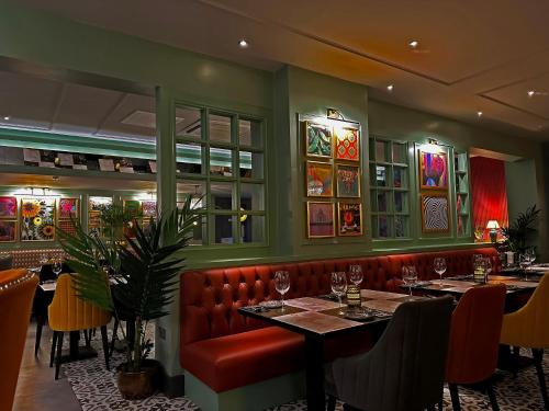 un restaurante con 2 mesas y un asiento de cuero rojo en Best Western New Kent Hotel, en Newcastle