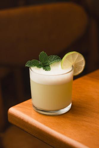 a drink with a lime and mint on a wooden table at Strassen Hotel in Goiânia