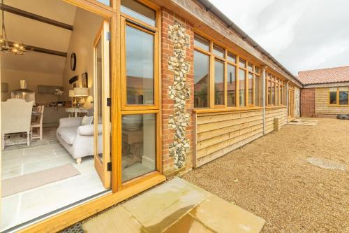 a home with a sliding glass door to a patio at Hill Farm Massingham in Little Massingham