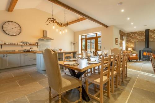 a kitchen and dining room with a wooden table and chairs at Hill Farm Massingham in Little Massingham