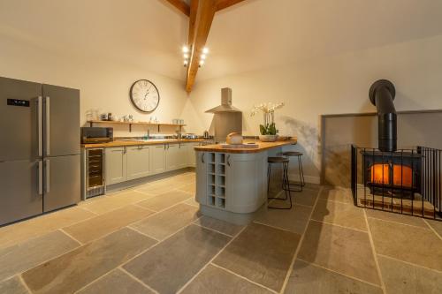 a kitchen with a fireplace in the middle of it at Hill Farm Massingham in Little Massingham