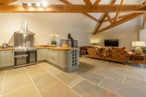 a kitchen and living room with wooden ceilings at Hill Farm Massingham in Little Massingham