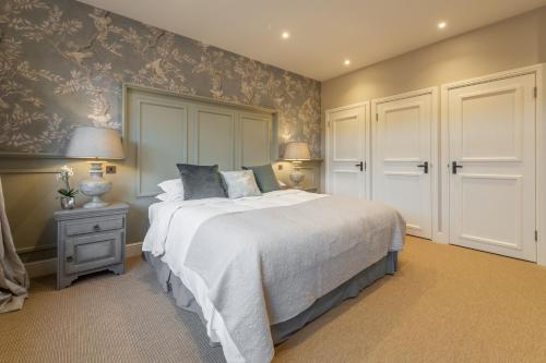 a bedroom with a bed and a wall with wallpaper at Hill Farm Massingham in Little Massingham
