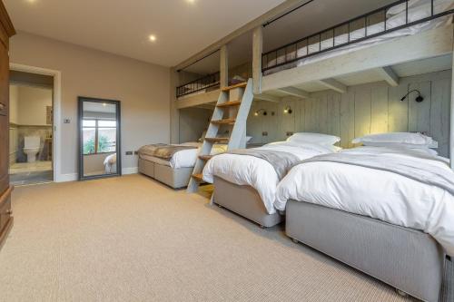 a bedroom with two bunk beds and a staircase at Hill Farm Massingham in Little Massingham