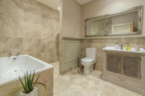 a bathroom with a sink and a toilet and a mirror at Hill Farm Massingham in Little Massingham