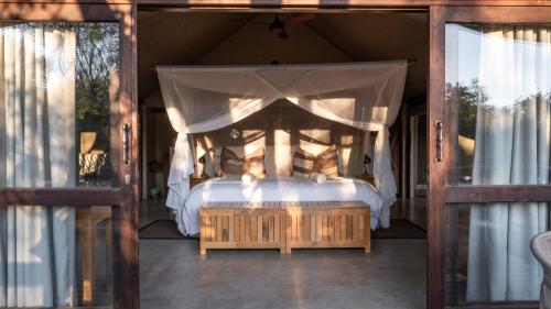 ein Schlafzimmer mit einem Himmelbett in der Unterkunft Tuli Safari Lodge Mashatu in Lentswelemoriti