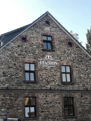 un bâtiment en briques avec un panneau sur son côté dans l'établissement Pension Westerhuesen, à Magdebourg