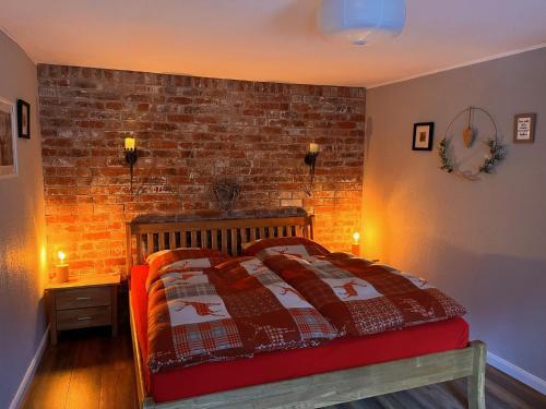 a bedroom with a bed with a brick wall at Ferienwohnung Hexenstube 2 in Tanne