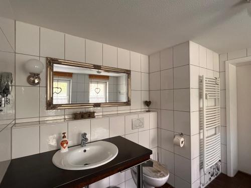 y baño con lavabo y espejo. en Ferienwohnung Hexenstube 2, en Tanne