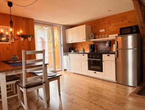 a kitchen with white cabinets and a stainless steel refrigerator at Ferienwohnung Hexenstube 2 in Tanne