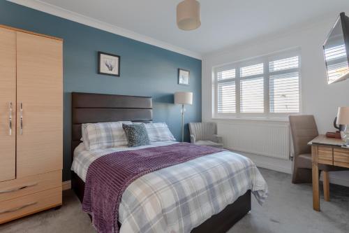 a bedroom with a bed and a desk and window at Room in Guest room - Apple House Wembley in Edgware