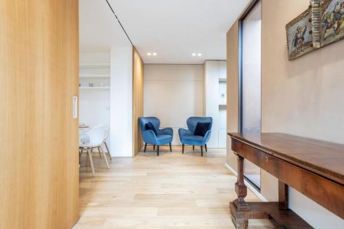 a hallway with blue chairs and a table at Luna di mare - nuovo appartamento sul mare in Acireale